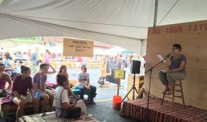 Author reads poetry onstage at Cleveland Flea