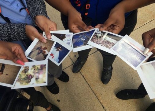 Students hold instant photographs