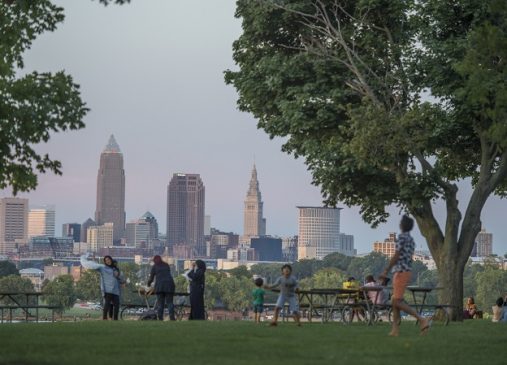 A family playing together at Edgewater Park with Cleveland skyline in background