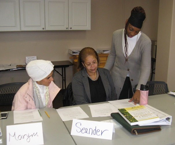 Three women sit at table for Encore volunteer training session 