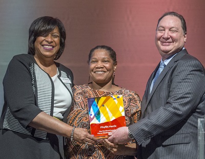India Pierce Lee, Phyllis Harris and Ronn Richard hold the 2017 Homer C. Wadsworth Award onstage at Cleveland Foundation Annual Meeting