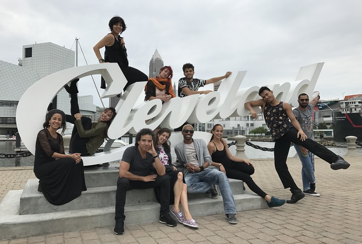 Malpaso Dance Company dancers pose in front of Cleveland script sign 