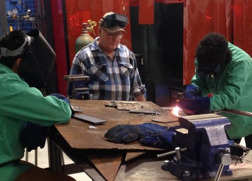 Gary Dudich, retired Journeyman Ironworker and Technical Corps Program Member assists welding students at Max S. Hayes High School with practice welds.