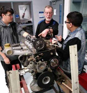 Rich Eskra, retired diesel mechanic instructs Max S. Hayes High School 12th grade diesel students on the mechanics of a snow blower.