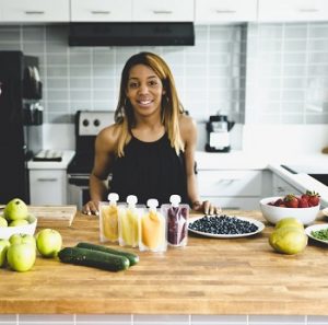 BabyMunch founder LeAnna Miller poses with fresh fruits and vegetables and her baby food product