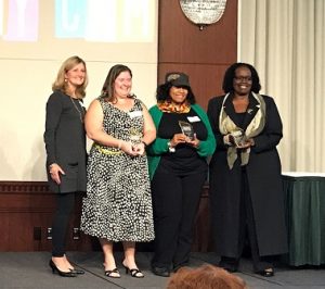 Winners of the 2017 MyCom Youth Voice Awards Caring Adult category stand onstage with their awards 