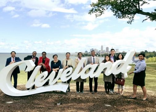 Cleveland Foundation fellows stand in front of Cleveland script sign with Lake Erie and Cleveland skyline behind