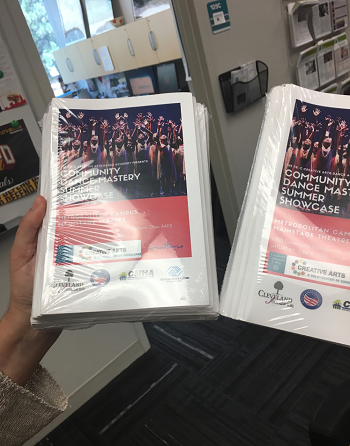 Noni holding printed programs for TriC summer camp