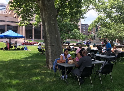 Image of people sitting outside eating lunch at memorial mondays