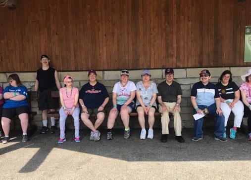 A group of people seated on bench in front of building