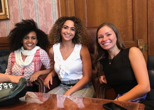 Christina sits with two fellow summer internship cohort members