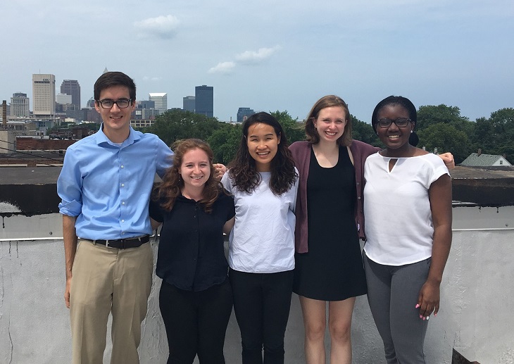 Group of summer interns stands in front of Cleveland skyline