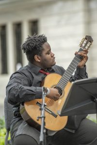 A mastery arts student performs classical guitar