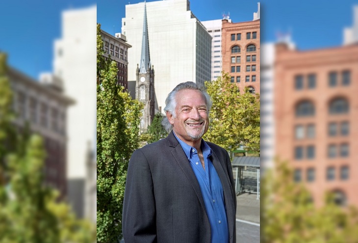 Ed Rivalsky stands outside in Cleveland Public Square with buildings in the background