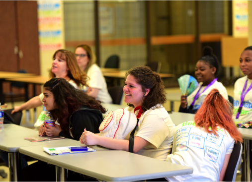 A group of students sit at tables