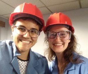 Cris and a fellow intern pose in hard hats 