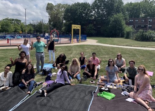 A group of summer interns seated on the ground at Outhwaite Park