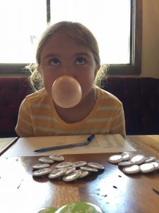 a girl blows a bubble with gum