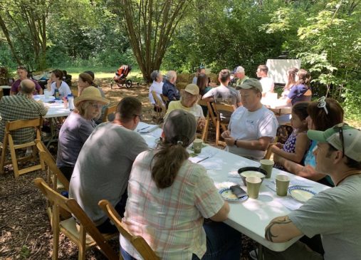 People sit outside at a group of tables