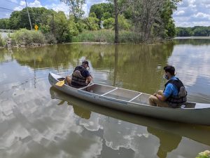 Two men paddle a canoe 