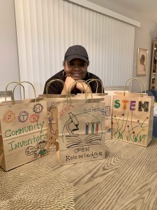 A woman poses with STEM kits 