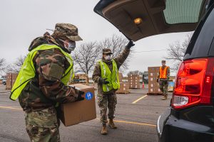 Volunteers load food at drive-through distribution event