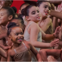 A group of young dancers perform onstage