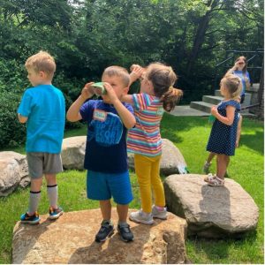 A group of young children explore outdoors