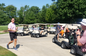 People in golf carts get ready for the golf outing