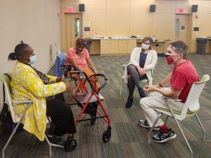 Four people sit in a circle facing one another as part of an improv group