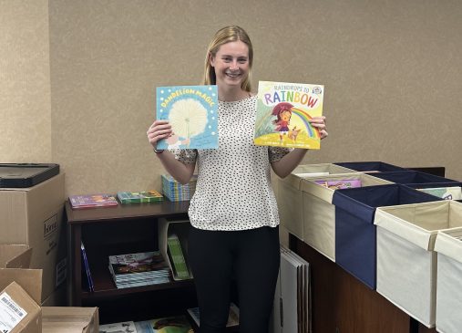 Photo of summer intern Elizabeth Keller holding up books