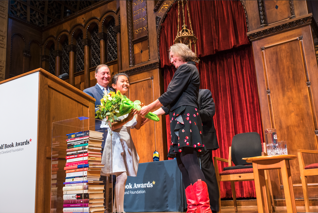 Kite Lin accepting flowers from Karen R. Long on stage